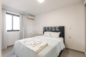 a white bedroom with a large bed with white sheets at Cozy 2 Br In Ciudad Del Este in Puerto Presidente Franco +31 photos