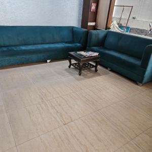 a living room with a blue couch and a coffee table at Hotel Indra in Jaipur