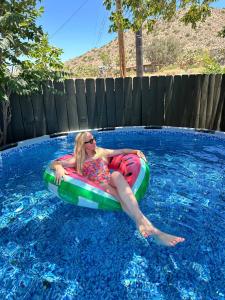 a woman laying on a raft in a swimming pool at Joshua Tree - Under the Stars-Pool, Spa & Fire pit in Yucca Valley