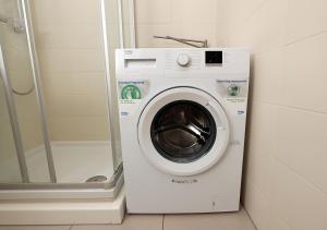 a washing machine in a bathroom next to a shower at Ferienwohnung Inselzoo der WAG in Altenburg