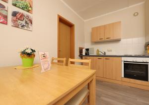 a kitchen with a wooden table and a counter top at Ferienwohnung Inselzoo der WAG in Altenburg