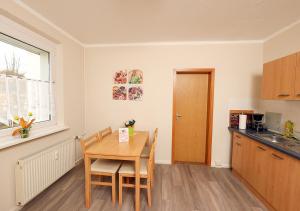 a kitchen with a wooden table and a dining room at Ferienwohnung Inselzoo der WAG in Altenburg