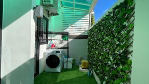 a balcony with a green plant on the side of a building at Townhouse in the Wonderland in Bang Tao Beach