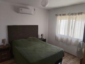 a bedroom with a bed and a window with a fan at Verde in Cuchilla Alta