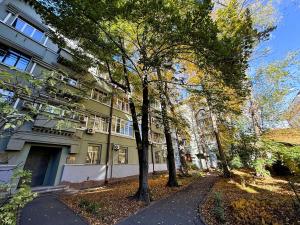 a building on a street with trees in front of it at Kyiv Kingdom Apartments in Kyiv