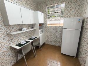 kuchnia z dwoma stołami i lodówką w obiekcie Paqueta · Paquetá 2 quartos - AC , Wi-Fi e Churrasqueira! w mieście Paquetá