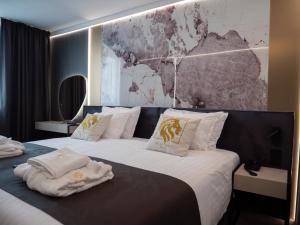 a hotel room with two beds with towels on them at Aslan Gold Hotel in Varna City