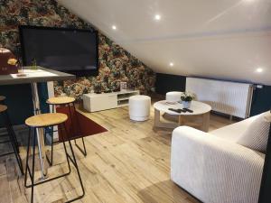 een woonkamer met een flatscreen-tv aan de muur bij Loft envie deux in Rivery