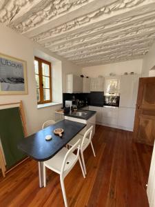 a kitchen with a table and chairs in a room at T2 avec jardin Jausiers in Jausiers