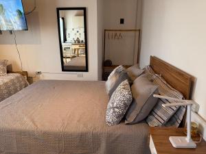 a bedroom with a bed with pillows and a mirror at MerloINK3 in Merlo