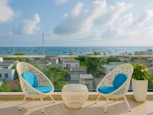 3 sillas en un balcón con vistas al océano en Amory Villa Mui Ne, en Mui Ne