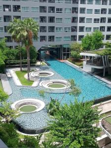 una piscina en medio de un edificio en Pool View Cozy 1BR Great Value Stay near BTS, en Amphoe Phra Khanong