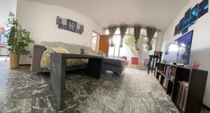 a living room with a couch and a tv at Habitación en Residencia Mendoza Ciudad in Mendoza