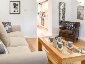 a living room with two chairs and a coffee table at Thornton Cottage in Grizebeck