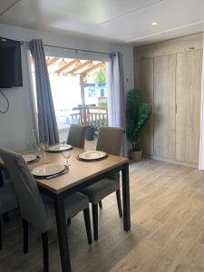 een eetkamer met een houten tafel en stoelen bij Au Petit Bonheur in Vias