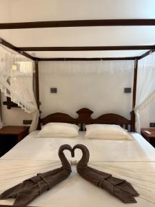 two swans are forming a heart on a bed at Taco Super Place in Unawatuna