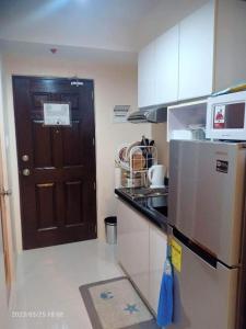 a kitchen with a black door and a refrigerator at Persimmon Studios Tower 3 in Cebu City