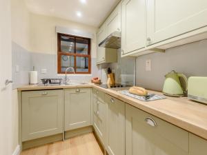 a kitchen with white cabinets and a counter top at Kissing Gate in Keswick +10 photos