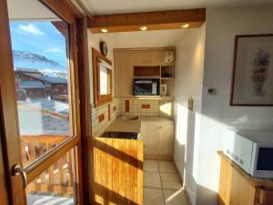 a small kitchen with a view of a balcony at Studio lumineux à Plagne Villages, balcon, proche pistes et commerces - FR-1-351-64 in La Plagne