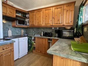 a kitchen with wooden cabinets and white appliances at Appartement au pied des pistes, 2 chambres, proche commerces, à Plagne Village - FR-1-351-181 in La Plagne Tarentaise