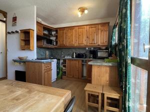 a kitchen with wooden cabinets and a wooden table at Appartement au pied des pistes, 2 chambres, proche commerces, à Plagne Village - FR-1-351-181 in La Plagne Tarentaise +5 photos