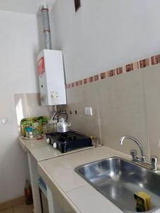 a kitchen counter with a sink and a stove at Apart Hotel Bell in San Fernando del Valle de Catamarca +26 photos
