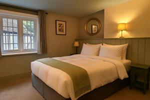 a bedroom with a large bed and a window at The Eight Bells Inn, Bolney in Bolney