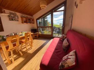 a living room with a red couch and a table at Appartement 5 personnes près des pistes avec vue magnifique - FR-1-733-172 in Crest-Voland