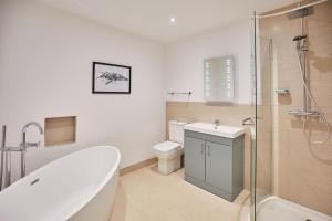 a bathroom with a tub and a toilet and a shower at Host & Stay - Swift View in Whitby