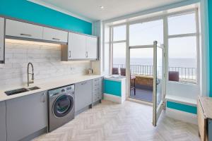 a kitchen with a washing machine and a view of the ocean at Host & Stay - Swift View in Whitby