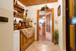 a kitchen with a door leading into a kitchen with people at Veltierhof Villnöß in Funes