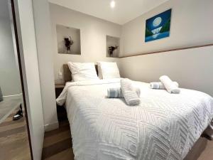 a bedroom with a large bed with white sheets and pillows at In The Heart Of The City - Cosy Studio - Close to RER in Saint-Germain-en-Laye