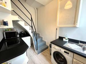 a small kitchen with a staircase with a washing machine at City Center - Duplex Studio - Close to RER in Saint-Germain-en-Laye