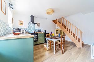 a kitchen with a wooden table and a staircase at La Girouette in Bazainville