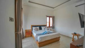 a white bedroom with a bed and a window at Villa Griya Anyar Ubud in Ubud +35 photos