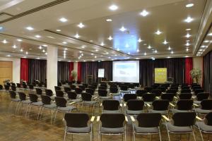 a conference room with chairs and a projection screen at Ringhotel Niedersachsen in Höxter +58 photos
