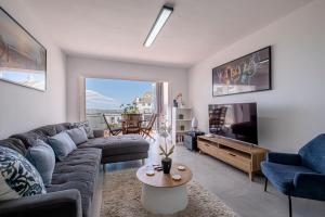 a living room with a couch and a tv at Ocean Breeze in Summerstrand