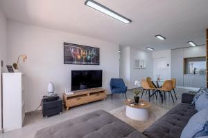 a living room with a couch and a flat screen tv at Ocean Breeze in Summerstrand