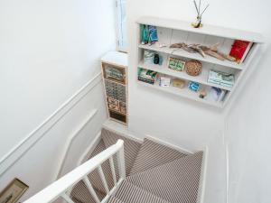 une cage d'escalier avec des murs blancs et des étagères blanches dans l'établissement The Lookout, à Polruan