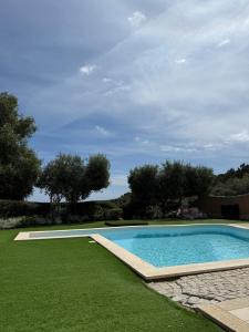 a swimming pool in a yard with green grass at Villa Bellavista Chia in Chia