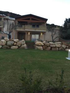 a house with a stone wall in front of a yard at Villa Bellavista Chia in Chia