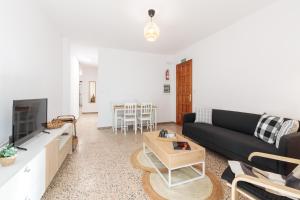 Una sala de estar con un sofá negro y un televisor. en CHL Armonía, see side views in Puerto Naos, en Puerto Naos