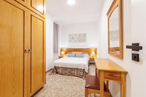 Un dormitorio con una cama, una mesa y un espejo. en CHL Armonía, see side views in Puerto Naos, en Puerto Naos