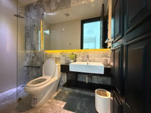 Un baño con inodoro, lavabo y espejo. en 2 Bedroom Pool Villa Chalong, en Ban Na Bon 9 fotos más