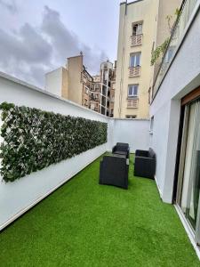 a courtyard with green grass on a building at 2 Bedroom 120 m2 with Terrace & Parking near La Défense & Champs Elysees in Neuilly-sur-Seine