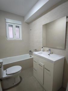 a bathroom with a sink and a toilet and a mirror at La Casa del Valle in Blanca