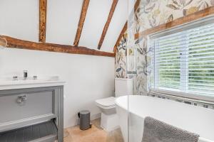 a bathroom with a white tub and a toilet at Quaint Cottage by the Castle in Kenilworth +35 photos