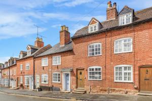 a row of red brick houses on a street at Quaint Cottage by the Castle in Kenilworth
