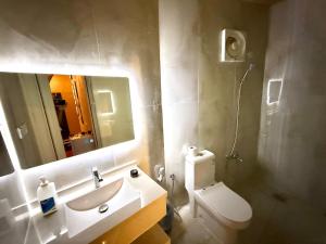 ein Badezimmer mit Waschbecken, Toilette und Spiegel in der Unterkunft Red Mountain Suites in Al-'Ula