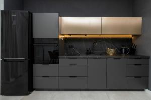 eine Küche mit weißen Schränken und einem schwarzen Kühlschrank in der Unterkunft Piastowska 30 Garden Free Parking by Renters Prestige in Przymorze